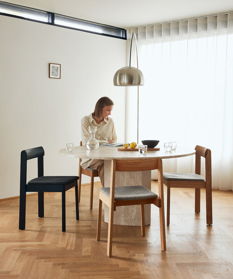Dining table with four Blueprint chairs and a large floor lamp which shines over the table