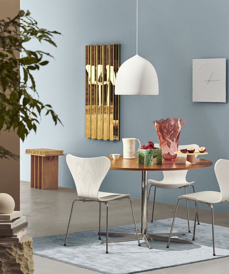Series 7 dining chair around a Fritz Hansen dining table below a white pendant light