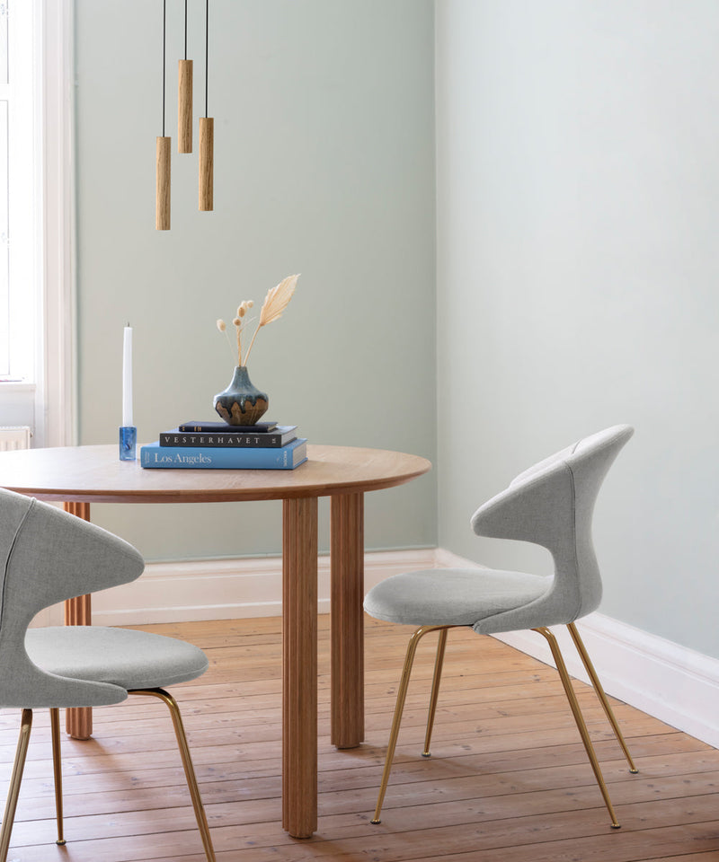 Featuring the Comfort Circle dining table in oak  with  two upholstered dining chairs around it