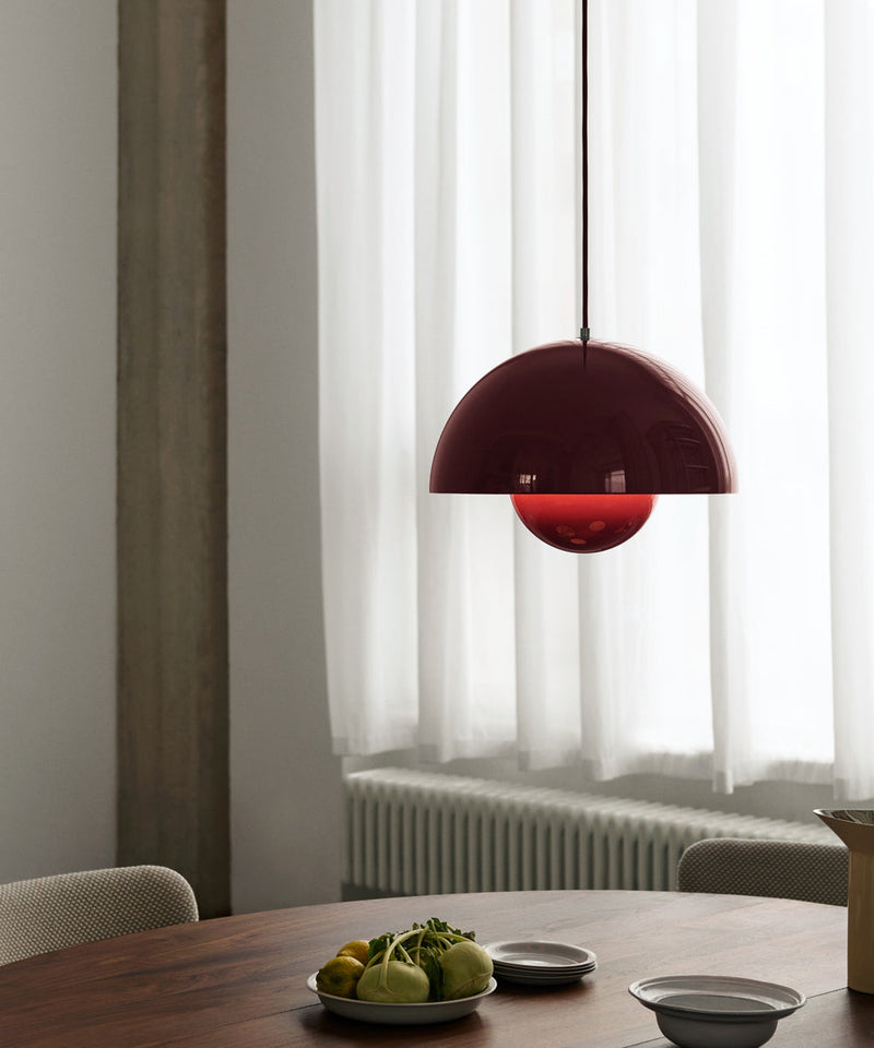 The VP7 Flowerpot pendant in dark plum hanging above a wooden dining table
