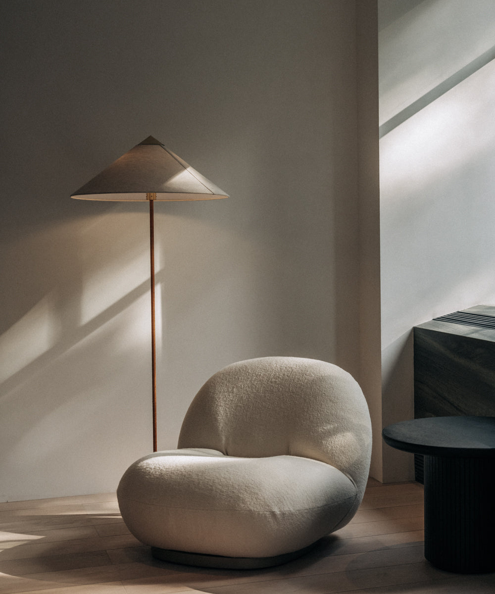 The GUBI Floor Lamp situated next to a lounge chair