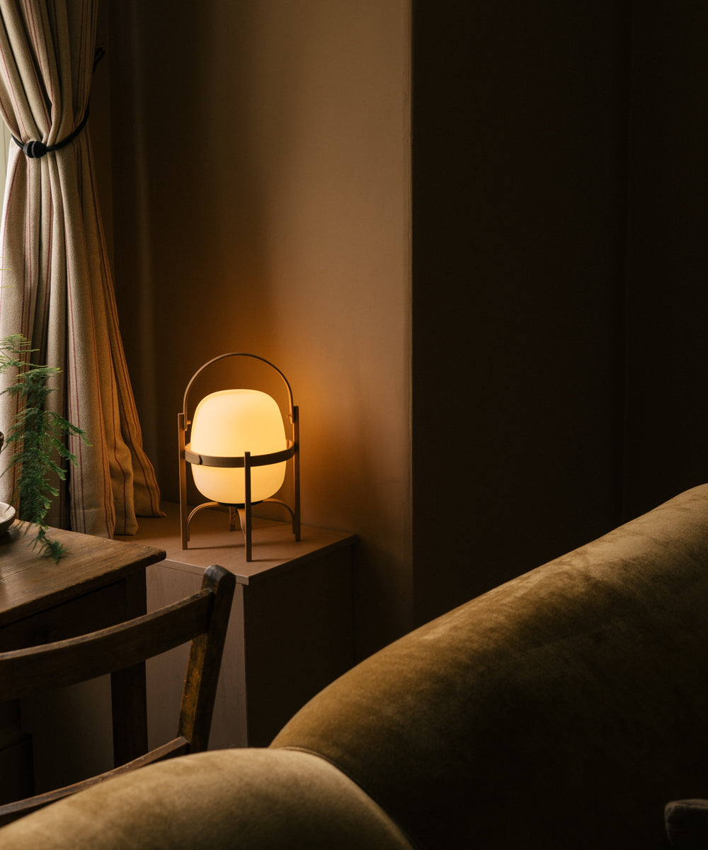 The portable lamp with a warm glow in the corner of a cosy living room