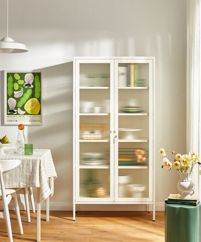 A storage cabinet with ribbed glass doors finished in a white chalk finish